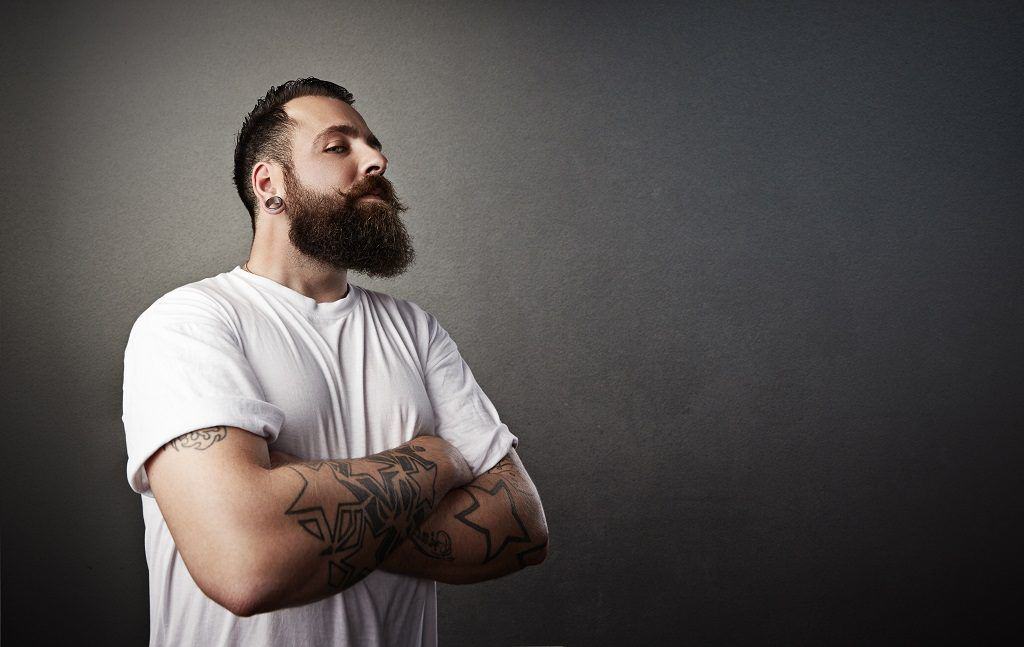 Serious Beard Man in a White T-Shirt and Tattoos 