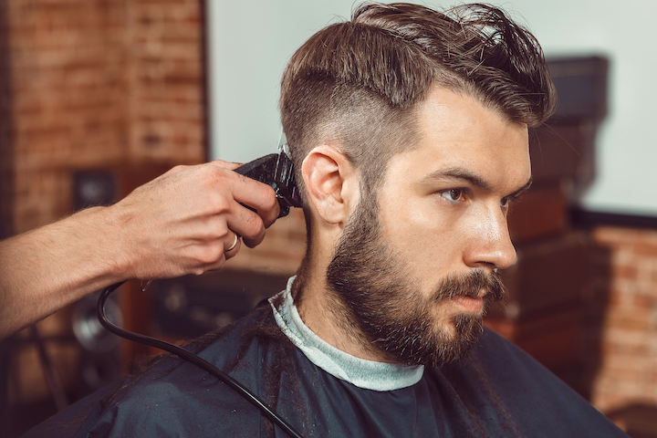 Barber Using Electric Trimmer to Cut Man's Hair