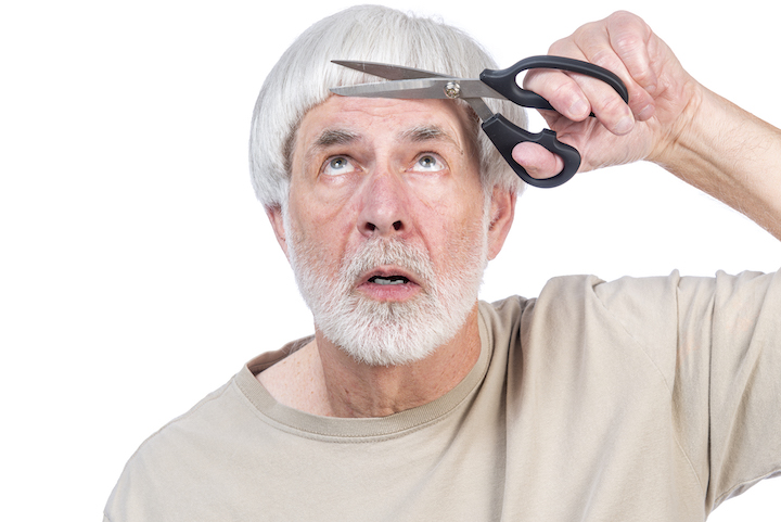 Older Man With Grey Hair Cutting Hair With Scissors