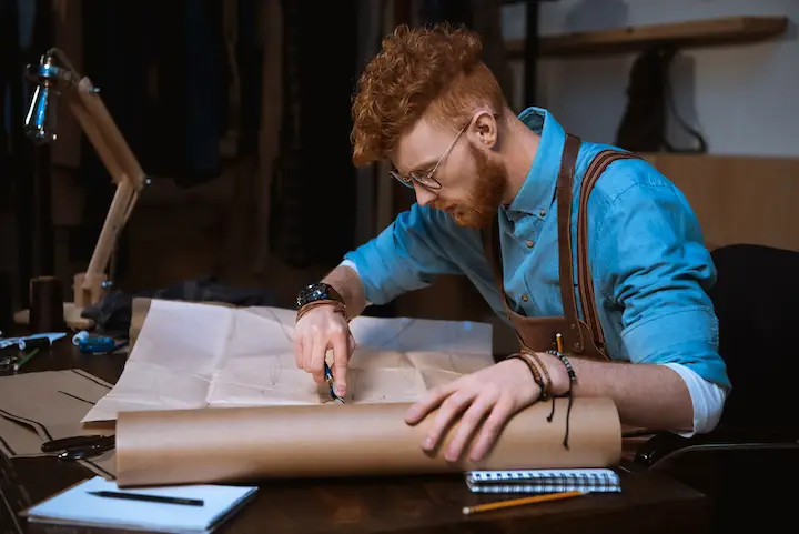 Guy With Glasses and Red Curly Hair Working on a Project