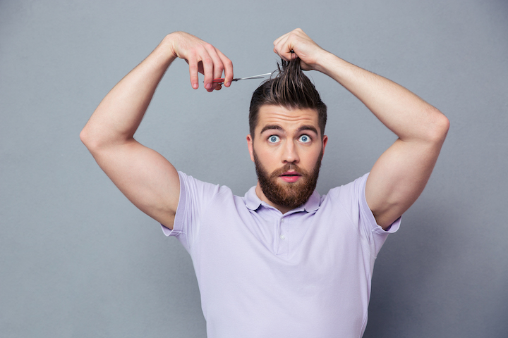 Bearded Man Cutting His Hair With Scissors