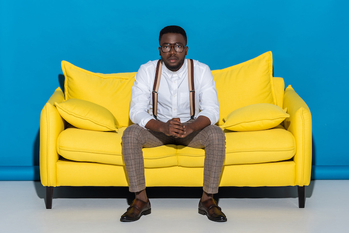 Black Man With Glasses Sitting on a Couch
