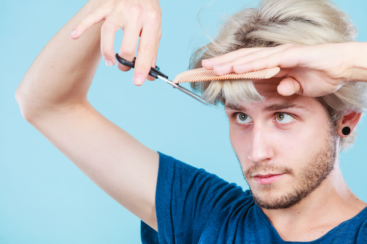 Blonde Guy Cutting His Bangs With Scissors