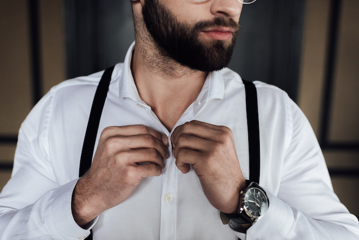 Buttoning Up White Shirt With Suspenders