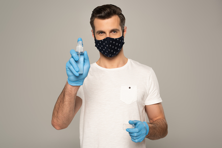 Man With a Mask and Glovers Holding a Disinfectant