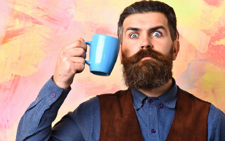 Serious Bearded Man Holding a Blue Mug