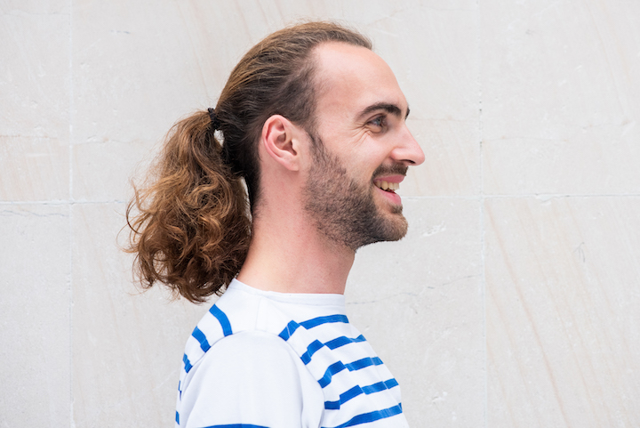 Smiling Bearded Man With a Long Curly Ponytail