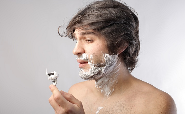 Man Shaving With a Disposable Razor