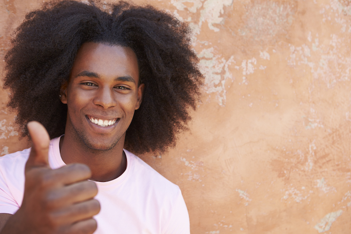 Young Smiling Black Man With Messy Hair Giving Thumbs Up