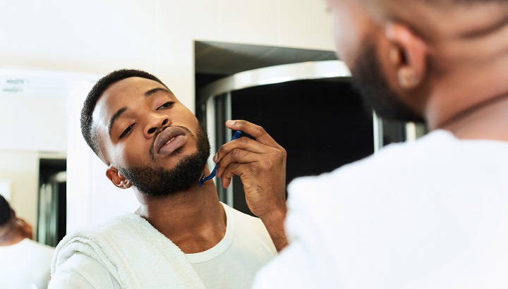Black Man Shaving His Beard With a Razor