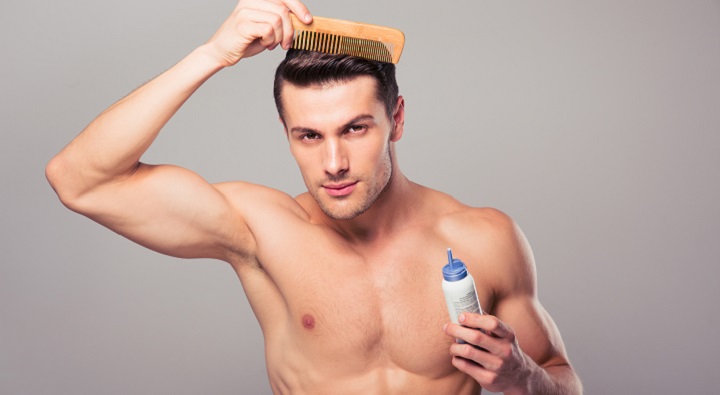 Young Man Combing His Hair With Big Wooden Comb