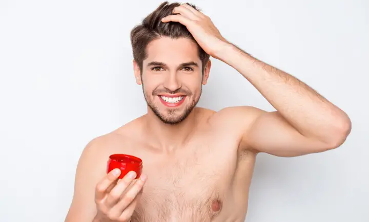 Smiling Man Putting Wax On His Hair