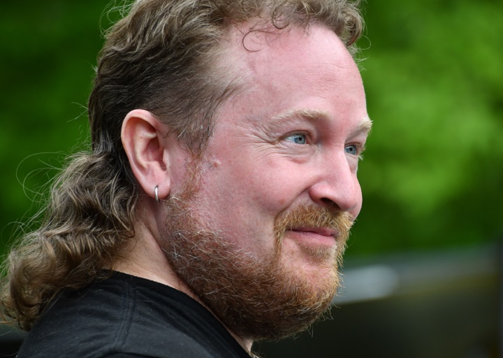 Man With Curly Mullet and Short Ginger Beard