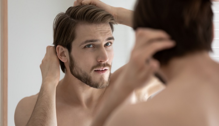 Bearded Man Looking His Hair in the Mirror