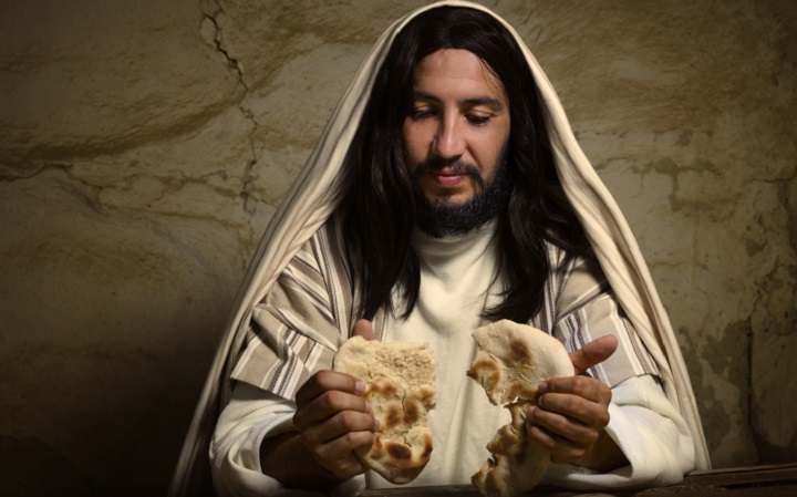Man In Jesus Mask Breaking Bread