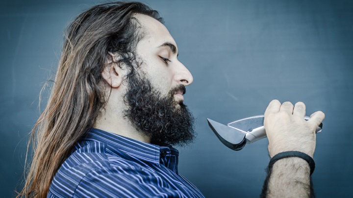 Man With a Long Hair and Beard Holding a Trimmer