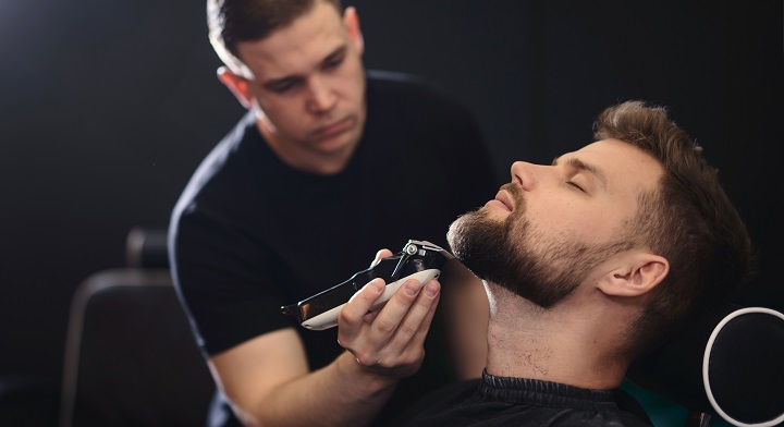 Barber Trimming Man's Beard