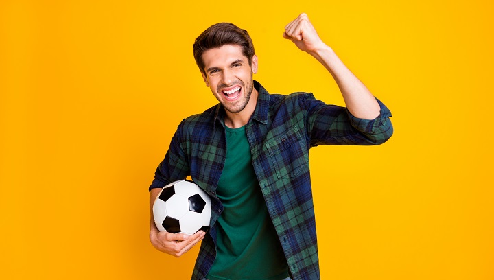 Joyful Young Guy With Soccer Ball in Hands