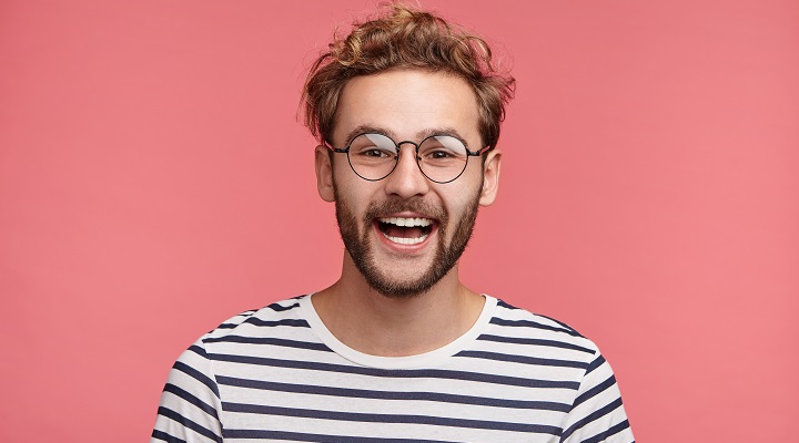 Smiling Teenager With Glasses, Curly Hair and Beard
