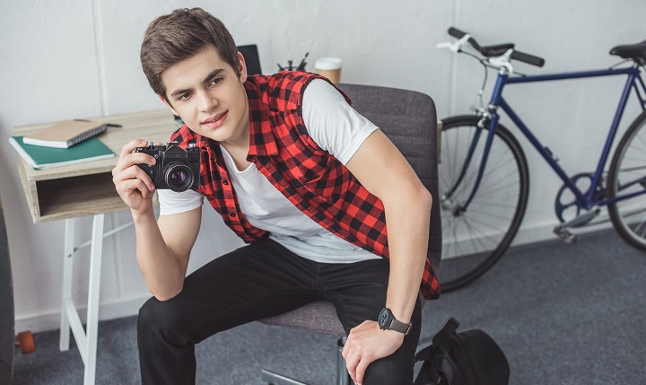 Young Man in a Red Shirt With a Camera in Hand