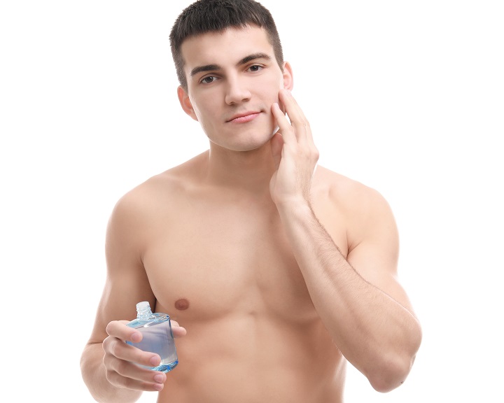 Shirtless Man Applying an Aftershave to His Face