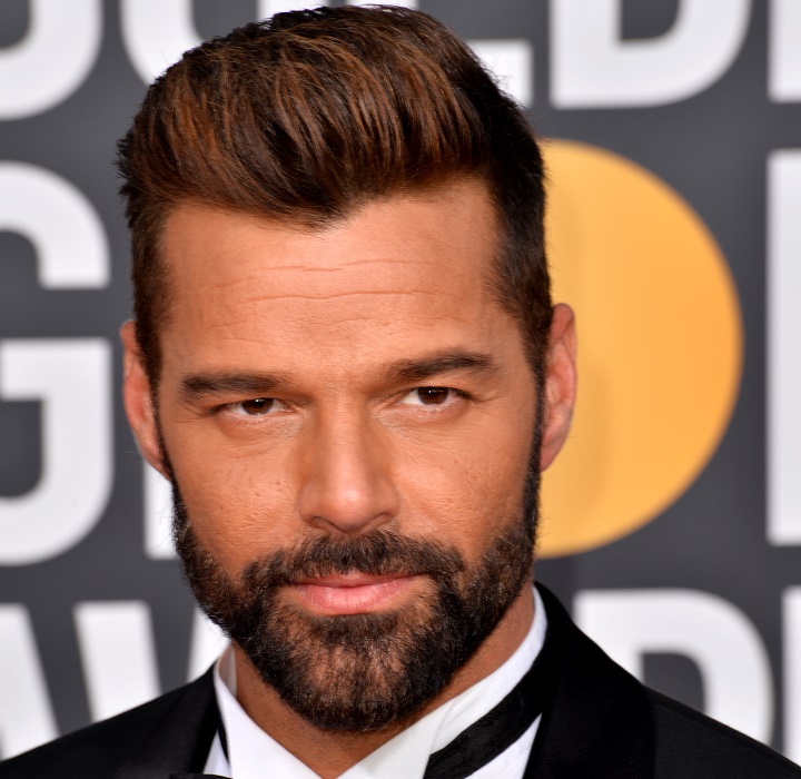 Bearded Ricky Martin With a High Top Comb-Over Hairstyle