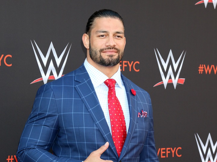 Roman Reigns in a Suit Wearing Man Bun Hairstyle and Short Beard
