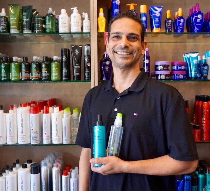 Smiling Man Holding Hair Care Products