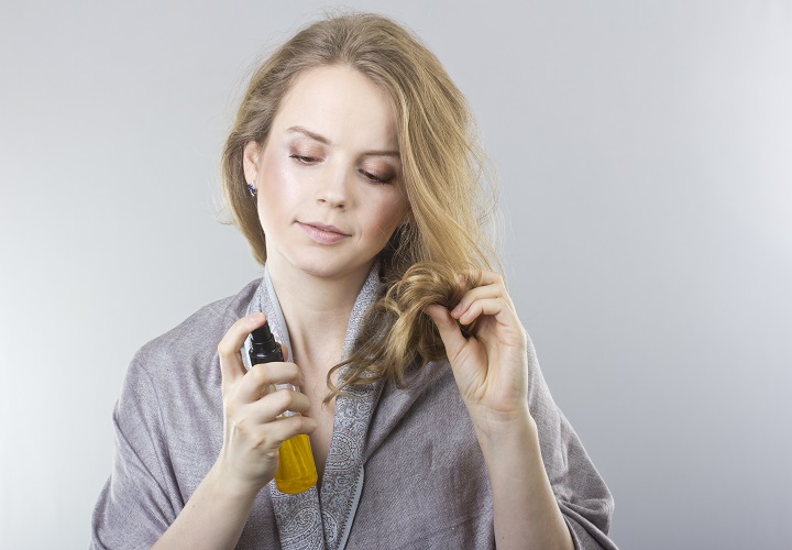 Woman Spraying Her Hair With a Hair Solution