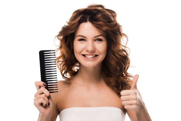 Smiling Woman With a Wavy Hair Holding a Comb