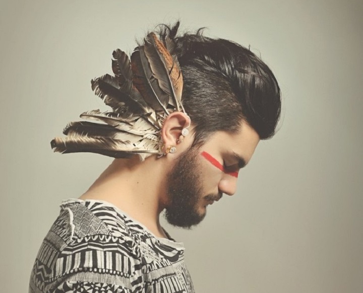 Young Bearded Aztec Man With Slicked Back Hair and Feathers Behind His Ear
