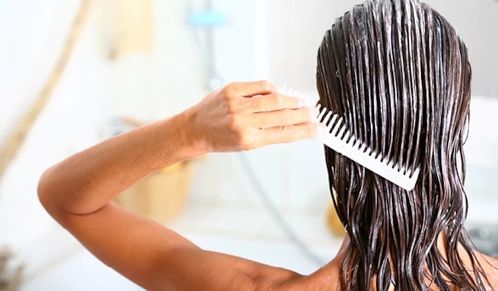 Spreading Homemade Hair Conditioner Across the Wet Hair With a Comb