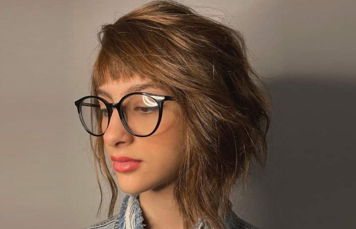 Girl With Glasess Wearing a Dimensional Asymmetrical Bob With Bangs