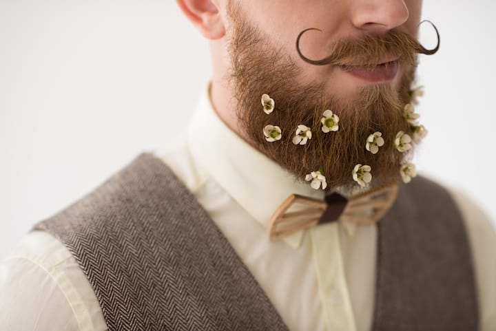 Bearded Man With a Handlebar Mustache Wearing Flowers as Beard Jewelry