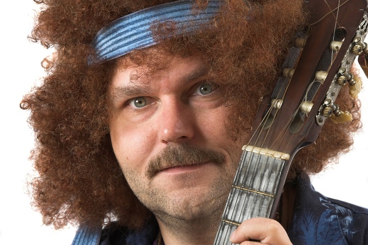 Man With Curly Hair Holding Guitar
