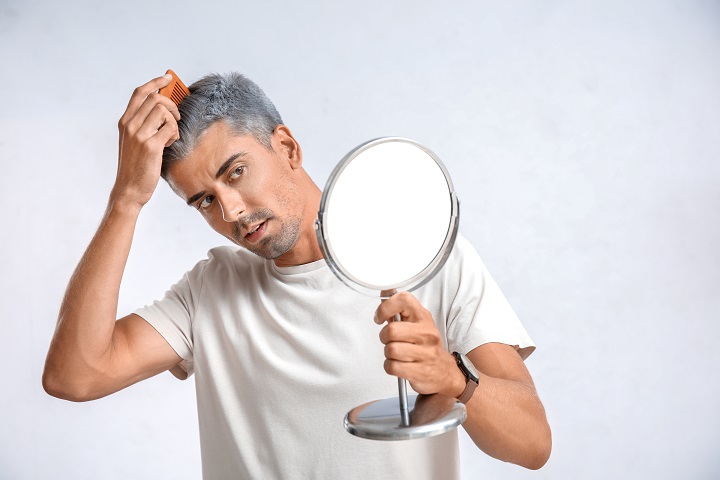 Man With Graying Hair Looking in Mirror 
