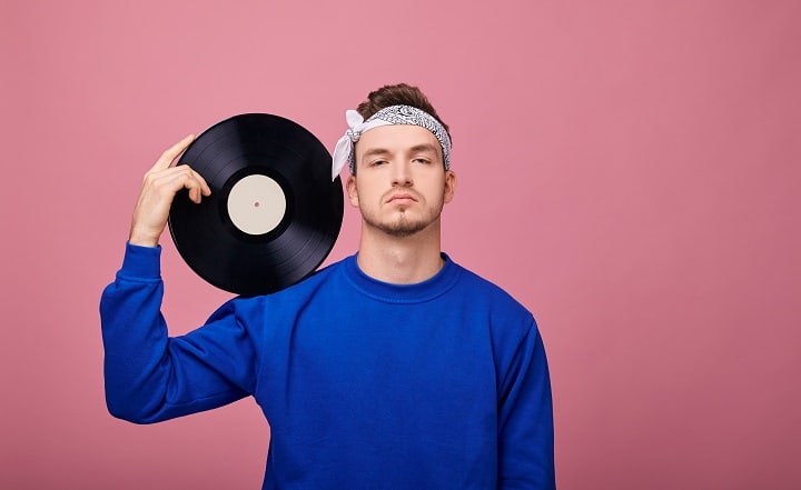 Man Wearing a Bandana With a Black Vinyl Record in His Hand