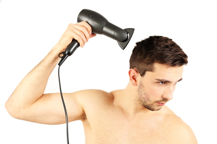 Young Man Blow Drying His Hair