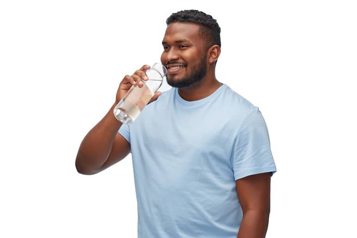 Black Man Drinking Water from Glass Bottle