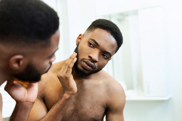 Black Man Looking His Beard in the Mirror