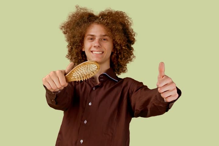 Curly Haired Man Showing Hair Brush
