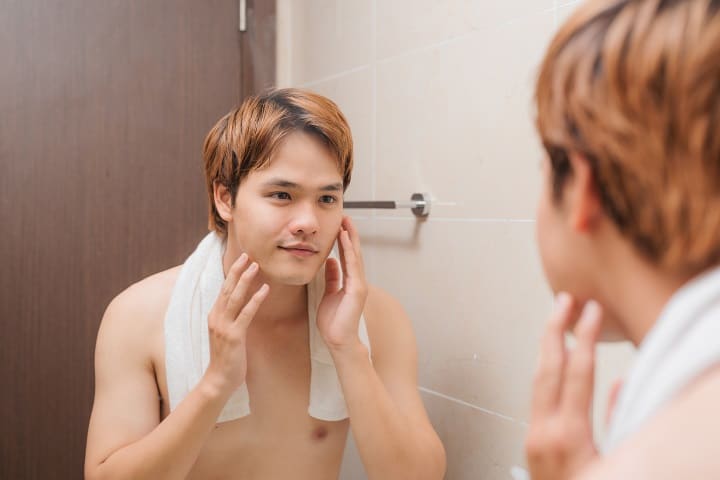 Korean Man Looking at Himself at the Mirror 