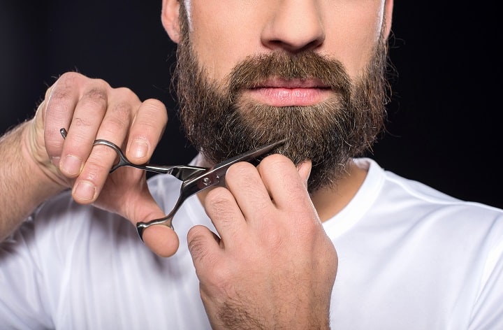 Man Is Cutting His Beard With Scissors