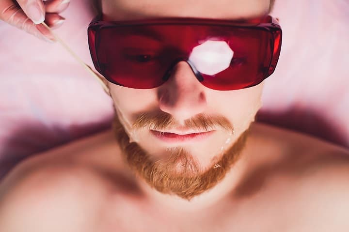 Man With Red Glasses Waxes His Beard
