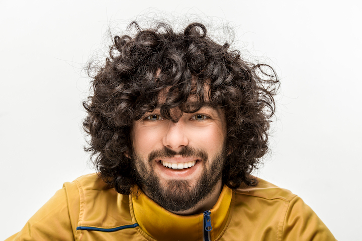 Smiling Young Man With Thick Curly Hair